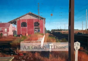 Edificio ferroviario rojo abandonado junto a vías, vegetación seca y cielo azul. Serie «Espacios habitados».